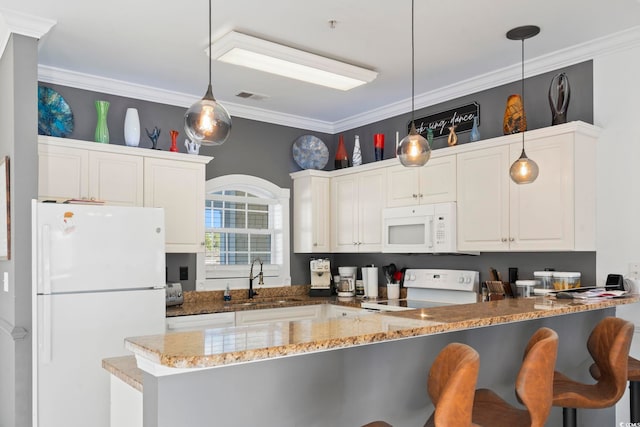 kitchen featuring white appliances, white cabinets, sink, decorative light fixtures, and kitchen peninsula