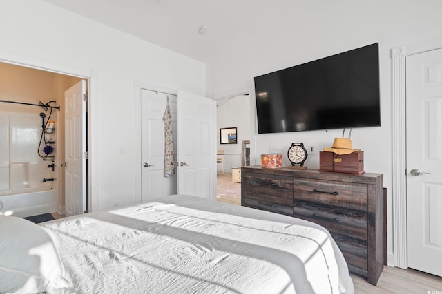 bedroom with light hardwood / wood-style floors and ensuite bath