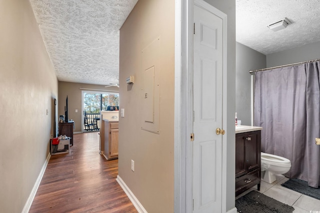 hall featuring a textured ceiling and light hardwood / wood-style flooring