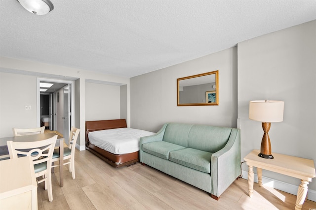 bedroom featuring a textured ceiling and light hardwood / wood-style flooring