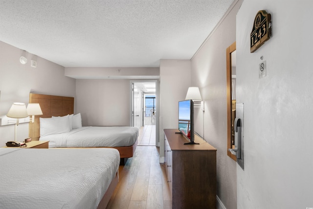 bedroom featuring a textured ceiling and light wood-type flooring