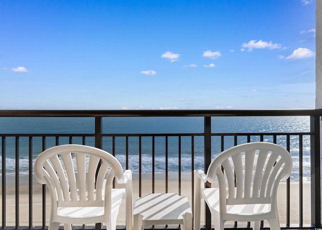 balcony featuring a beach view and a water view