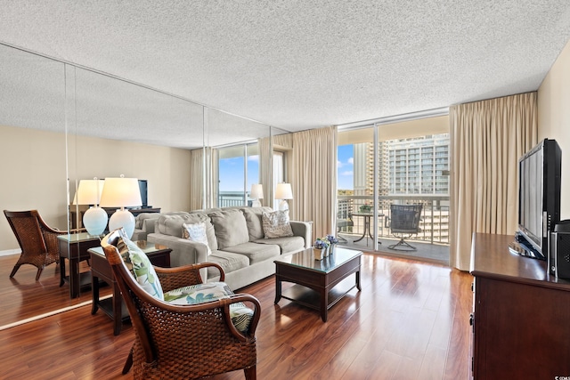 living room featuring hardwood / wood-style floors, floor to ceiling windows, and a textured ceiling