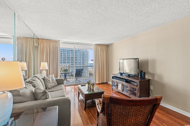 living room with a textured ceiling, hardwood / wood-style flooring, and floor to ceiling windows