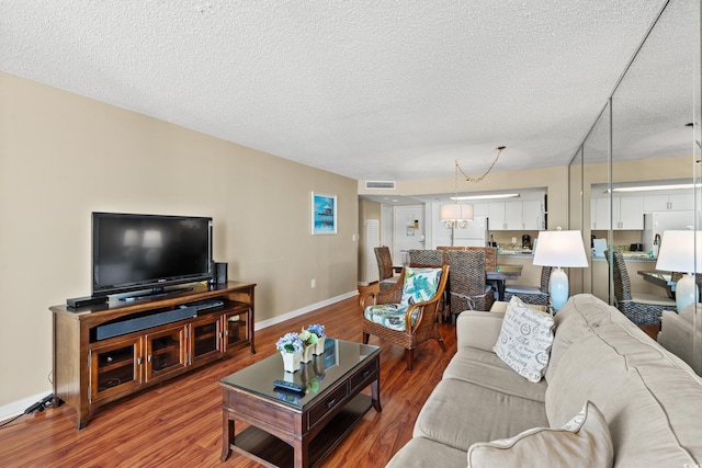 living room featuring a chandelier, a textured ceiling, and hardwood / wood-style flooring