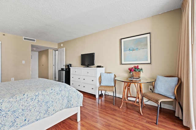 bedroom featuring hardwood / wood-style floors and a textured ceiling