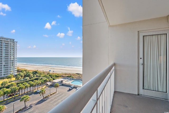 balcony featuring a view of the beach and a water view