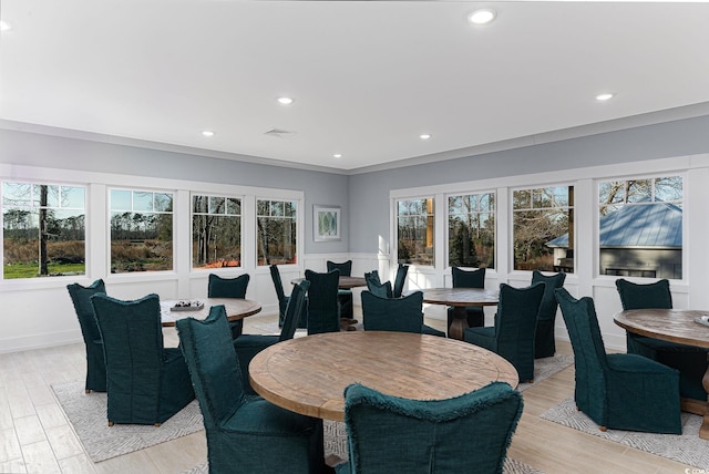 dining room featuring light hardwood / wood-style flooring and crown molding