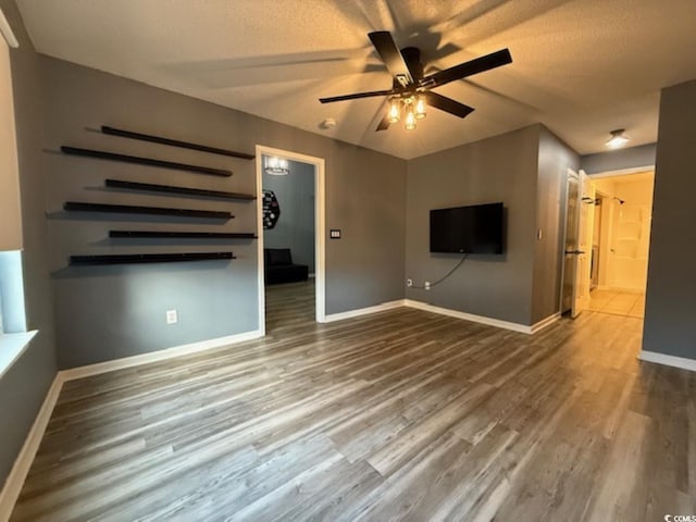 unfurnished living room featuring a textured ceiling, hardwood / wood-style flooring, and ceiling fan