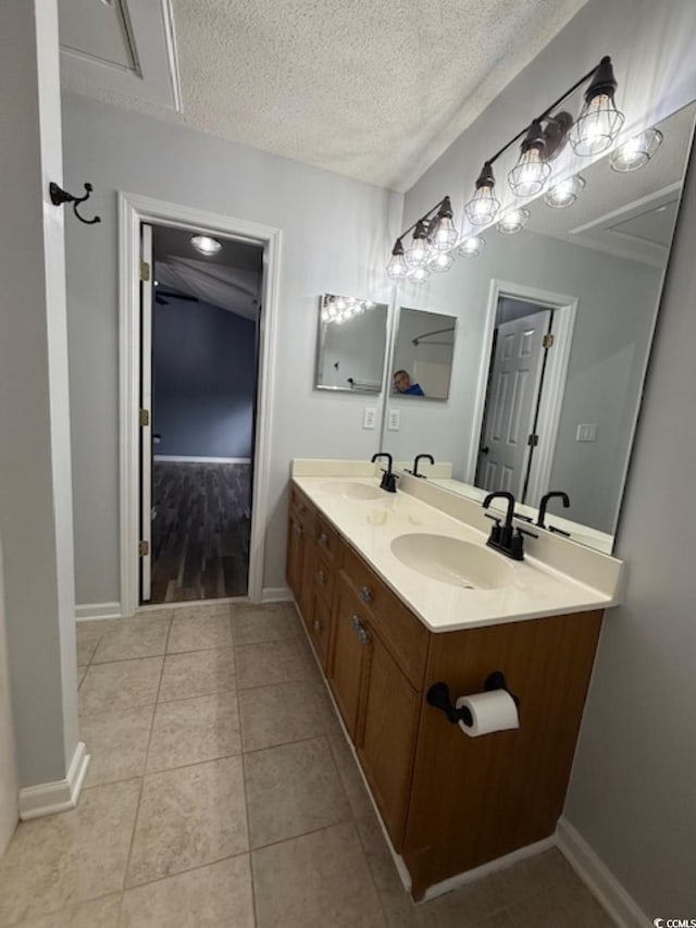 bathroom featuring tile patterned flooring, vanity, and a textured ceiling