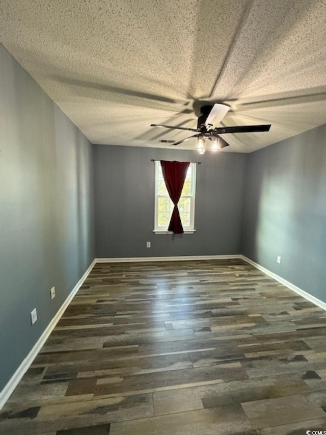 empty room with a textured ceiling, dark hardwood / wood-style flooring, and ceiling fan