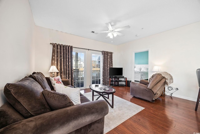 living room featuring ceiling fan and dark wood-type flooring