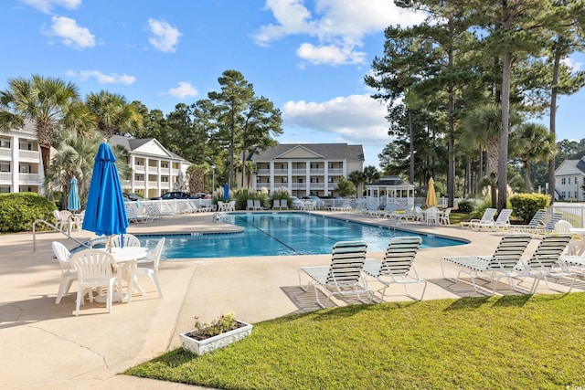 view of swimming pool with a yard and a patio