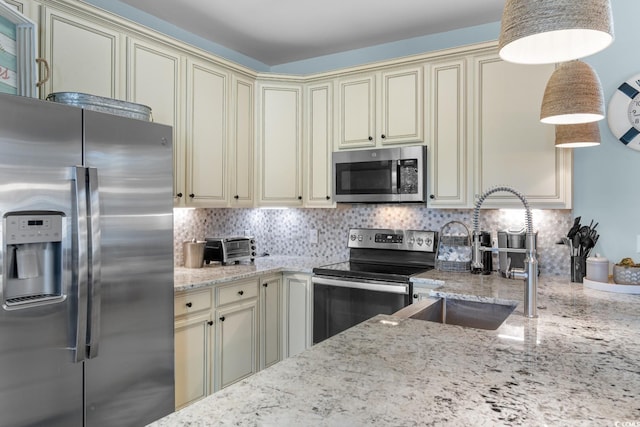 kitchen with decorative backsplash, sink, cream cabinets, and appliances with stainless steel finishes