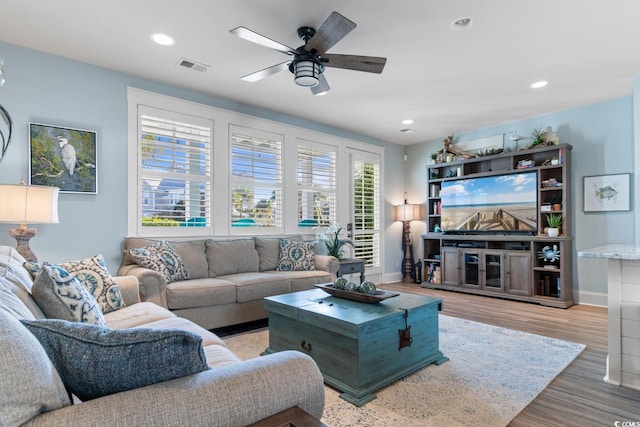 living room with wood-type flooring and ceiling fan