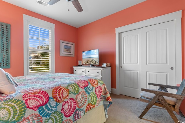 bedroom with ceiling fan, a closet, and light colored carpet