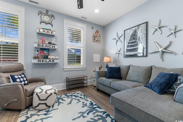 living room featuring ceiling fan and dark wood-type flooring