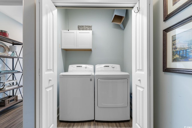 washroom featuring separate washer and dryer, light hardwood / wood-style floors, and cabinets