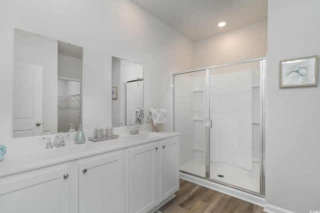 bathroom featuring wood-type flooring, vanity, and a shower with shower door