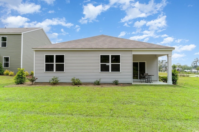 back of property with a yard and a patio