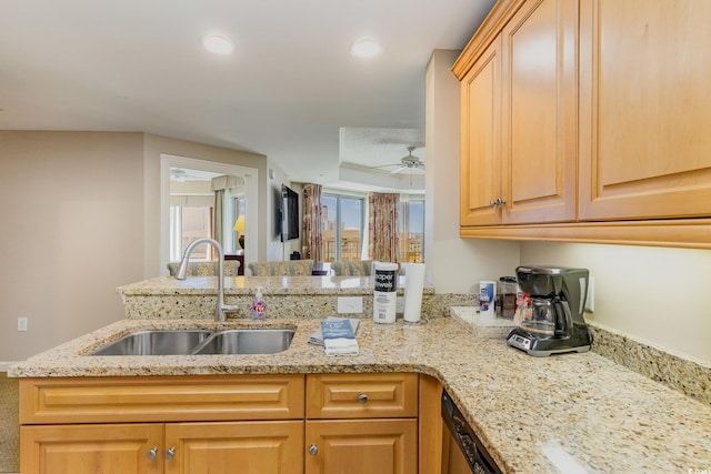 kitchen featuring kitchen peninsula, ceiling fan, sink, and light stone counters