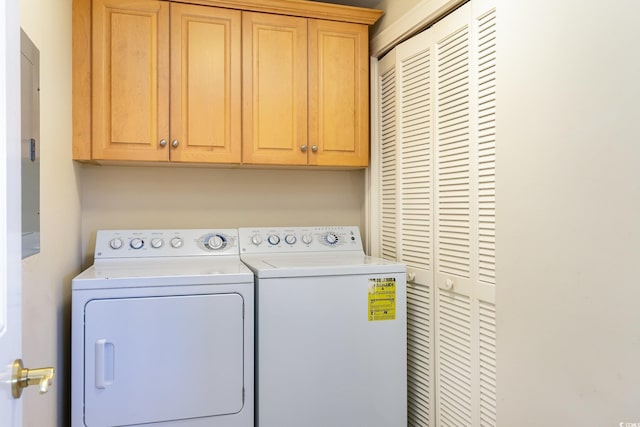 laundry room with washing machine and clothes dryer and cabinets