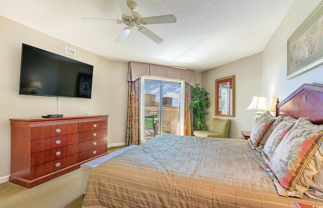 carpeted bedroom featuring ceiling fan, access to exterior, and a textured ceiling