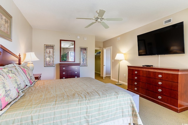 carpeted bedroom featuring ceiling fan, a spacious closet, and a closet