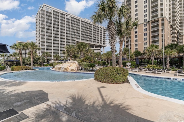 view of swimming pool featuring pool water feature and a patio