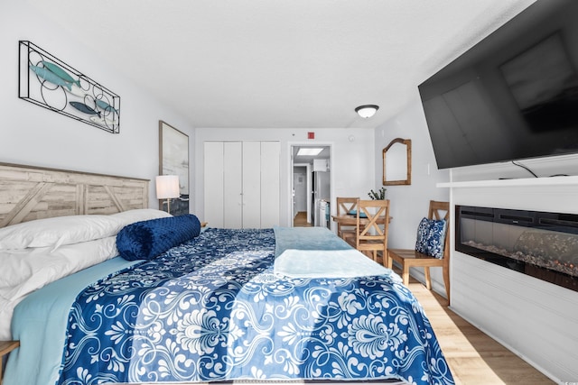 bedroom featuring wood-type flooring and stainless steel refrigerator