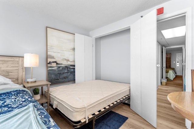 bedroom with hardwood / wood-style floors and a textured ceiling