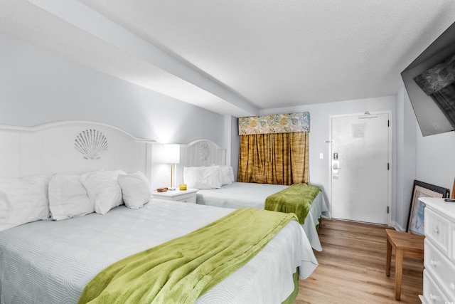 bedroom featuring a textured ceiling and light hardwood / wood-style flooring