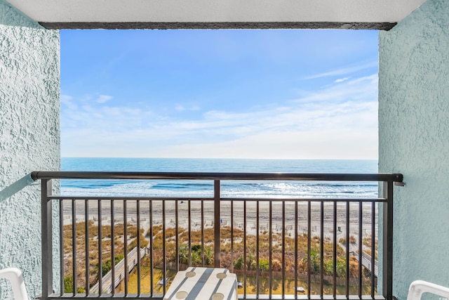 balcony with a water view and a beach view