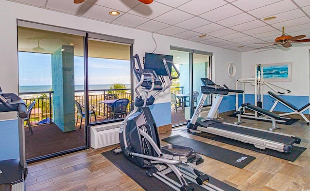 gym with a drop ceiling and ceiling fan