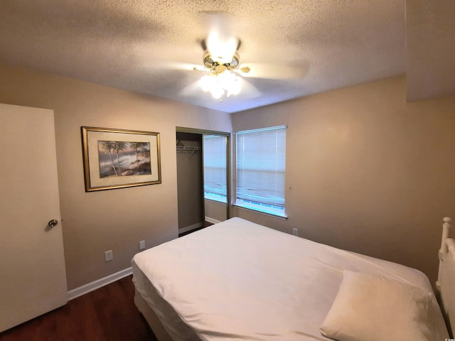 bedroom featuring a closet, a textured ceiling, dark hardwood / wood-style floors, and ceiling fan