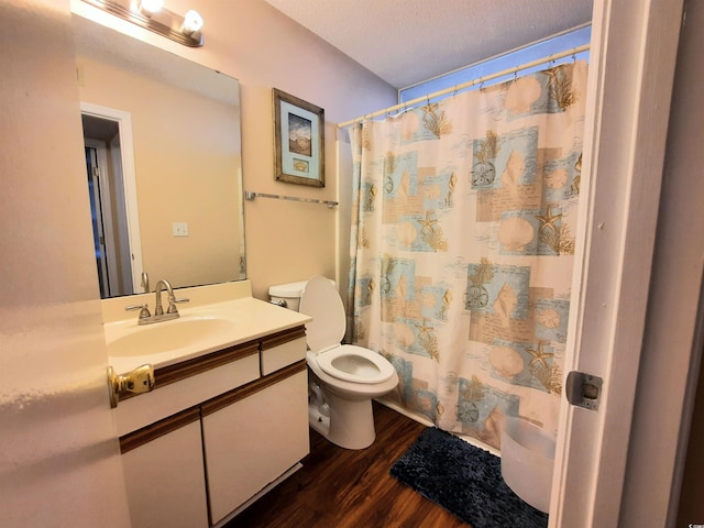 bathroom featuring vanity, toilet, a textured ceiling, walk in shower, and wood-type flooring