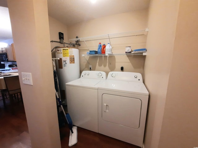 laundry room with separate washer and dryer, water heater, and a textured ceiling