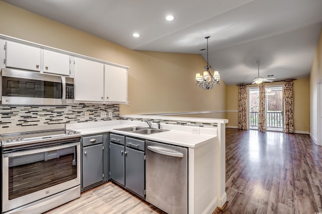 1286 River Oaks Dr Unit 8-M, Myrtle Beach, SC 29579 - kitchen with appliances with stainless steel finishes, a peninsula, backsplash, white cabinets, and vaulted ceiling