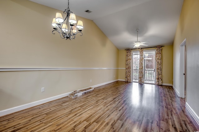 spare room featuring ceiling fan with notable chandelier, hardwood / wood-style flooring, and vaulted ceiling