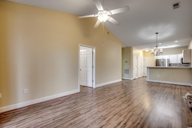 unfurnished living room featuring high vaulted ceiling, light hardwood / wood-style floors, and ceiling fan with notable chandelier