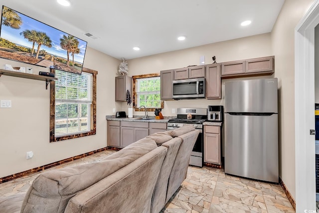 kitchen featuring gray cabinetry, sink, a healthy amount of sunlight, and appliances with stainless steel finishes