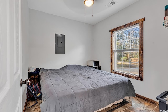 bedroom with ceiling fan and electric panel