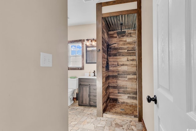 bathroom with vanity, toilet, and a tile shower