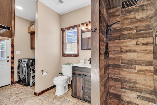 bathroom with washing machine and dryer, vanity, a healthy amount of sunlight, and toilet