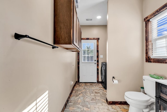 bathroom with washer and dryer and toilet