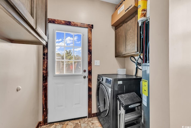 clothes washing area featuring cabinets and washer / dryer