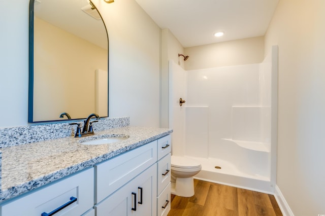 bathroom featuring hardwood / wood-style floors, vanity, toilet, and walk in shower