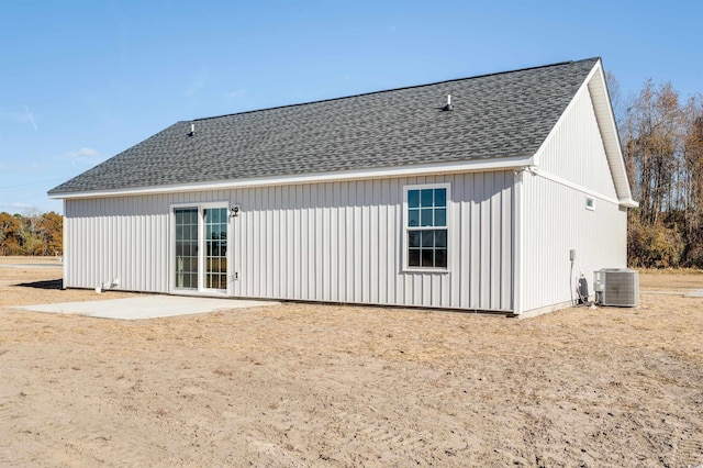 back of property with central AC unit and a patio