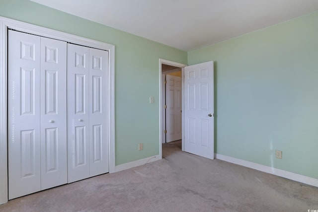 unfurnished bedroom featuring light carpet and a closet