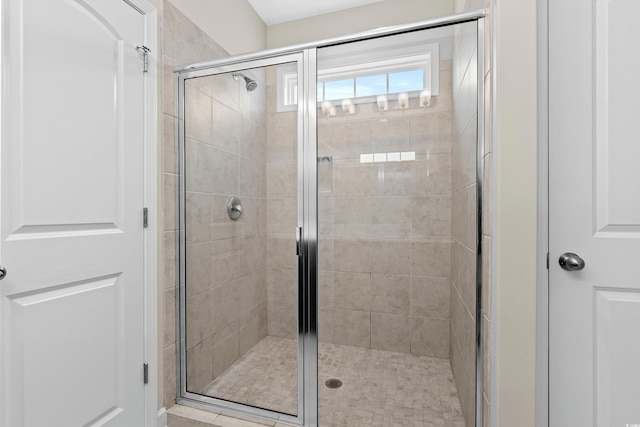 bathroom featuring a shower with door